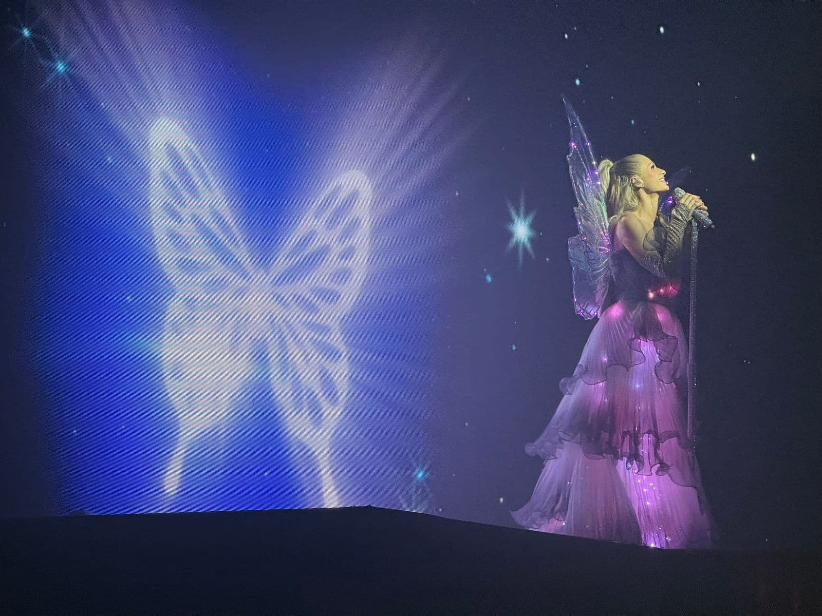 Paris Hilton performing in the lit gown and wings